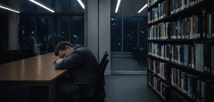 Hombre durmiendo en una biblioteca